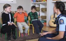 Three children talk with a police officer around road safety.