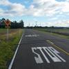 Stop sign controlled intersection - Johns Rd and Plasketts Rd looking west