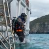 Navy diver ADR Luke Gordon from the Royal New Zealand Navy (RNZN) Operational Dive Team (ODT) enters the water in Akaroa Harbour