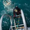 Navy diver ADR Luke Gordon from the Royal New Zealand Navy Operational Dive Team climbs back on board the HMNZS MANAWANUI