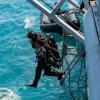 Navy divers from the Royal New Zealand Navy Operational Dive Team enter the water at the site of the sunken FV Jubilee