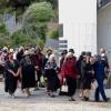 Superintendent Warwick Morehu walks with his whanau past the memorial wall 