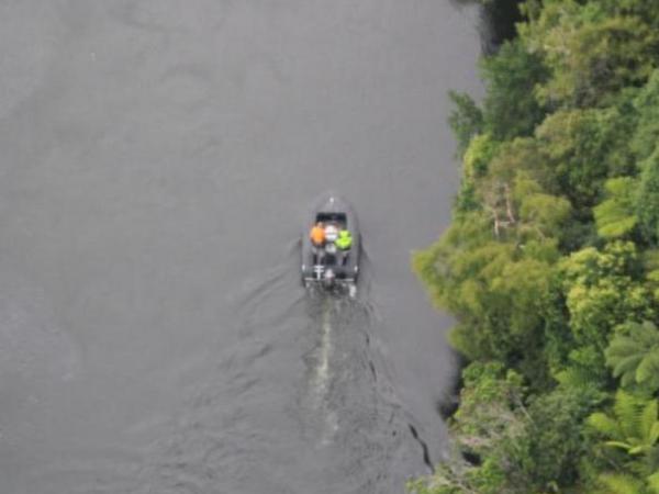 The Police helicopter flies over a Police launch searching the Waikato River