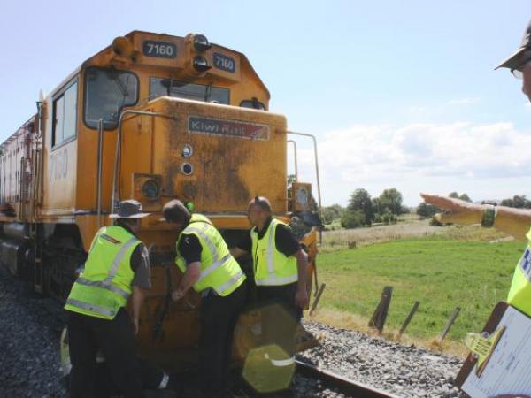 Police and Kiwi Rail staff check damage to the train