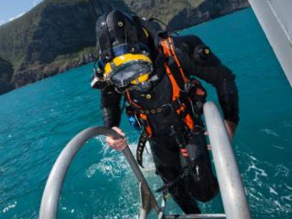 Navy diver ADR Luke Gordon from the Royal New Zealand Navy Operational Dive Team climbs back on board the HMNZS MANAWANUI