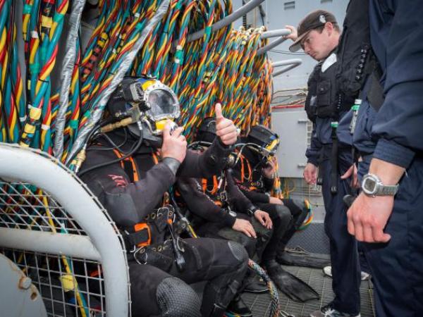 A Navy diver from the Royal New Zealand Navy Operational Dive Team gives the 'thumbs up' prior to diving from the HMNZS MANAWANU