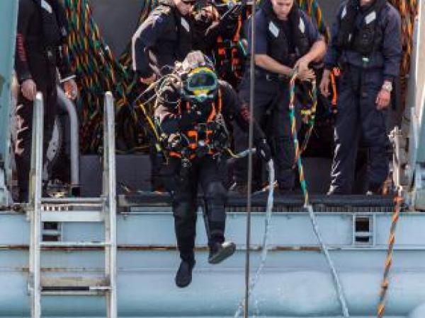 Navy divers from the Royal New Zealand Navy Operational Dive Team enter the water at the site of the sunken FV Jubilee