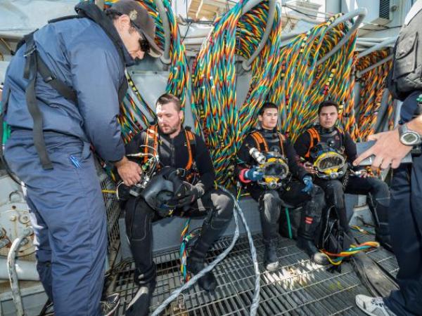 Members of the Royal New Zealand Navy Operational Dive Team prepare to enter the water at the site of the sunken FV Jubilee