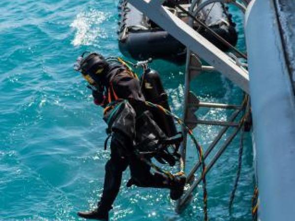 Navy divers from the Royal New Zealand Navy Operational Dive Team enter the water at the site of the sunken FV Jubilee