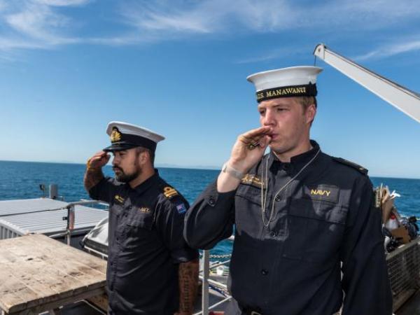 Members of the diving support vessel HMNZS MANAWANUI performing a ‘Piping of the Side’ as a mark of respect