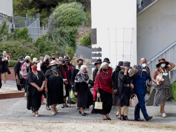 Superintendent Warwick Morehu walks with his whanau past the memorial wall 