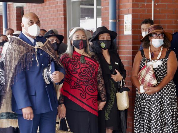 Warwick and his wife Leeanne Morehu (in red) and other members of his whanau wait to be welcomed