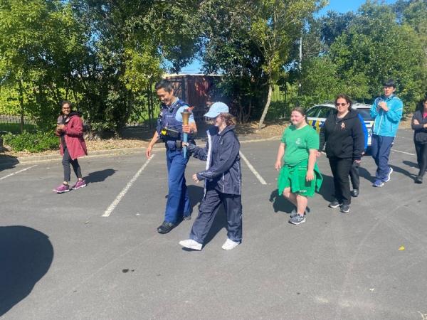 Acting Inspector Anson Lin walks with athletes from the Howick-Pakuranga club through the Manakau Velodrome.