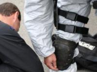 Taping up: A Hamilton Police officer is assisted in donning a protective chemical suit 